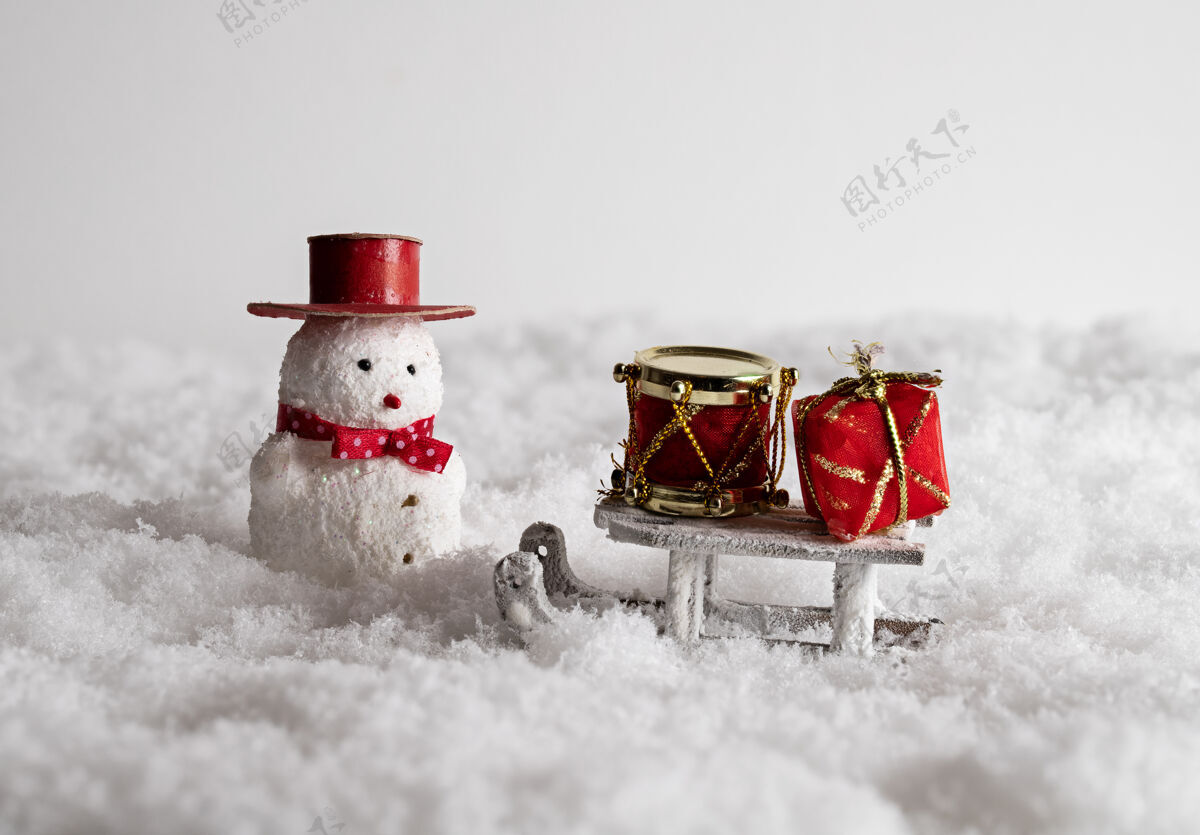 特写可爱的雪人玩具 雪橇 和五颜六色的礼品盒在雪地里玩具快乐心情