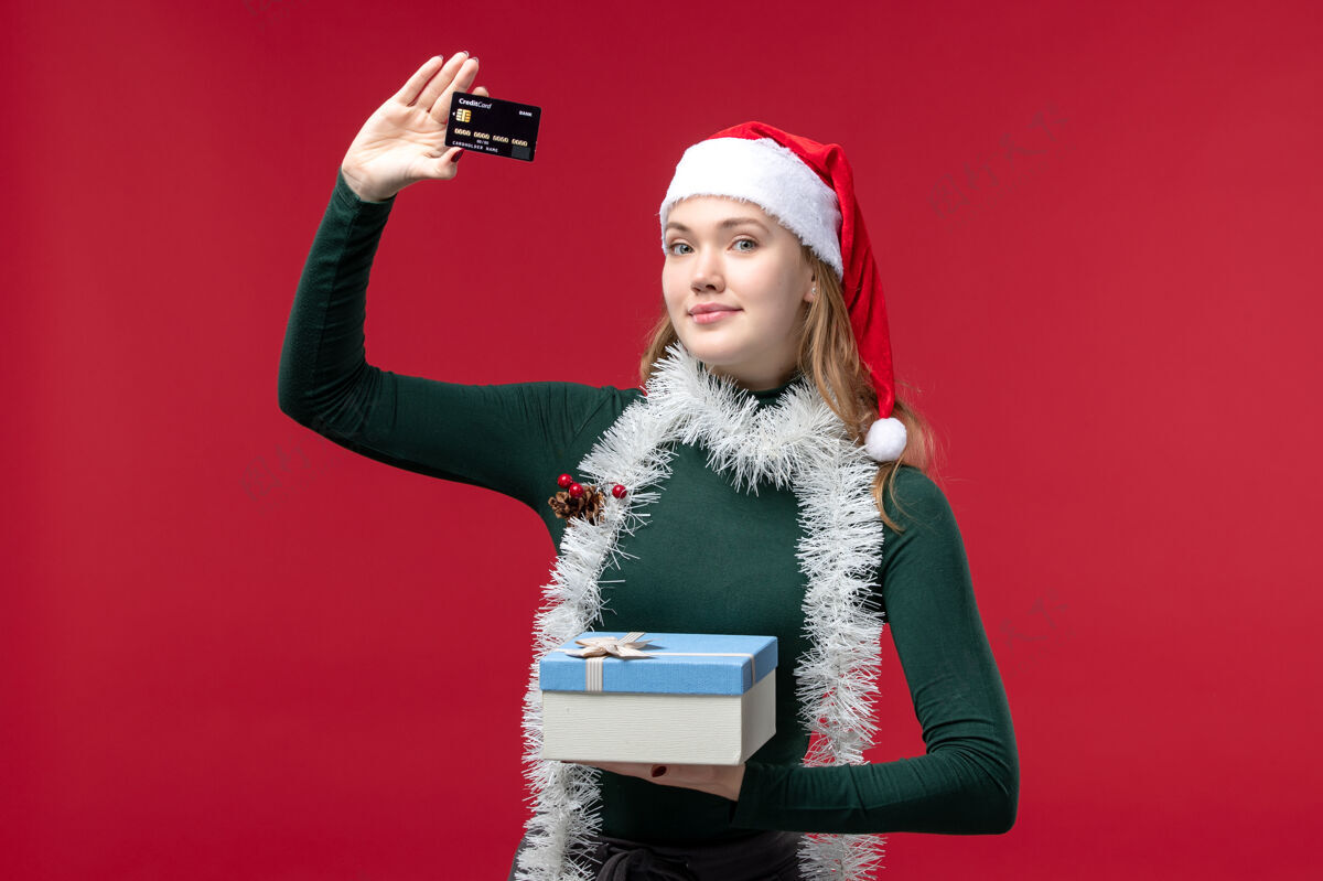 礼物正面图是一位年轻女士 带着礼物和红色背景的银行卡银行脸卡片
