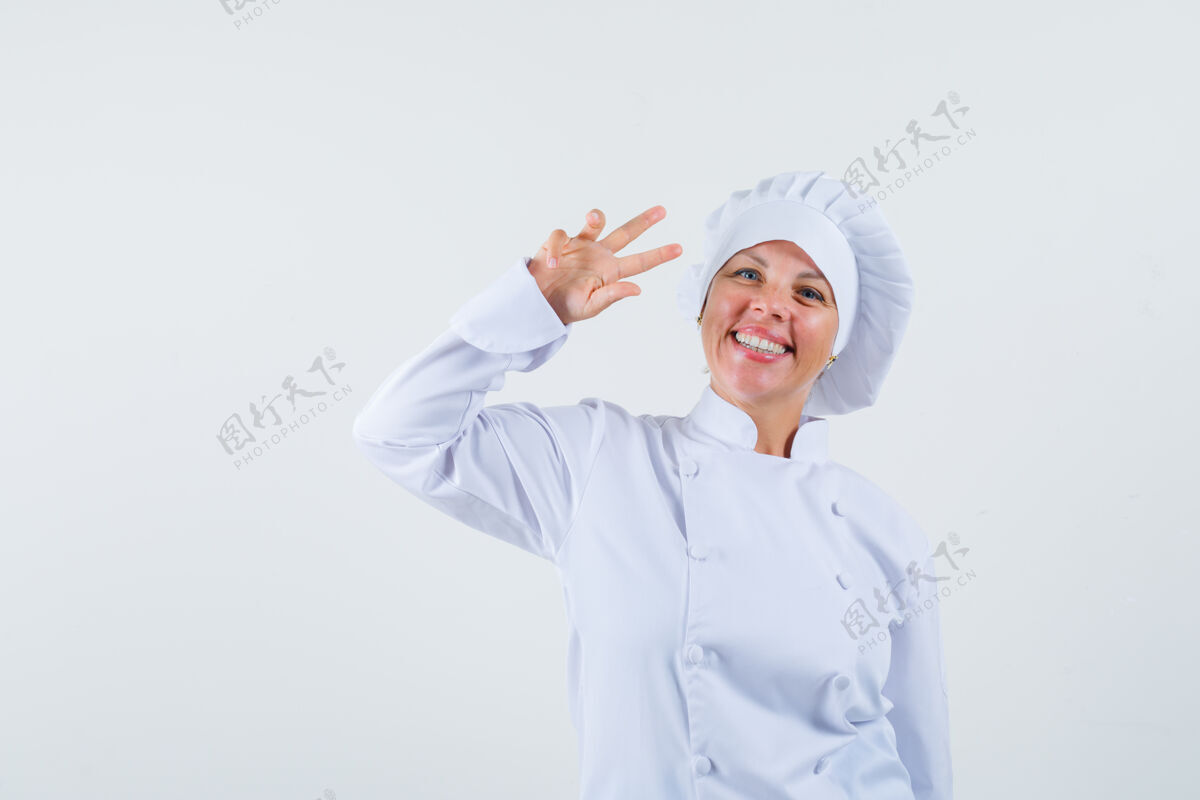 女性一位身穿白色制服的女厨师 脸上挂着v字 看上去很开朗厨师卷发外观