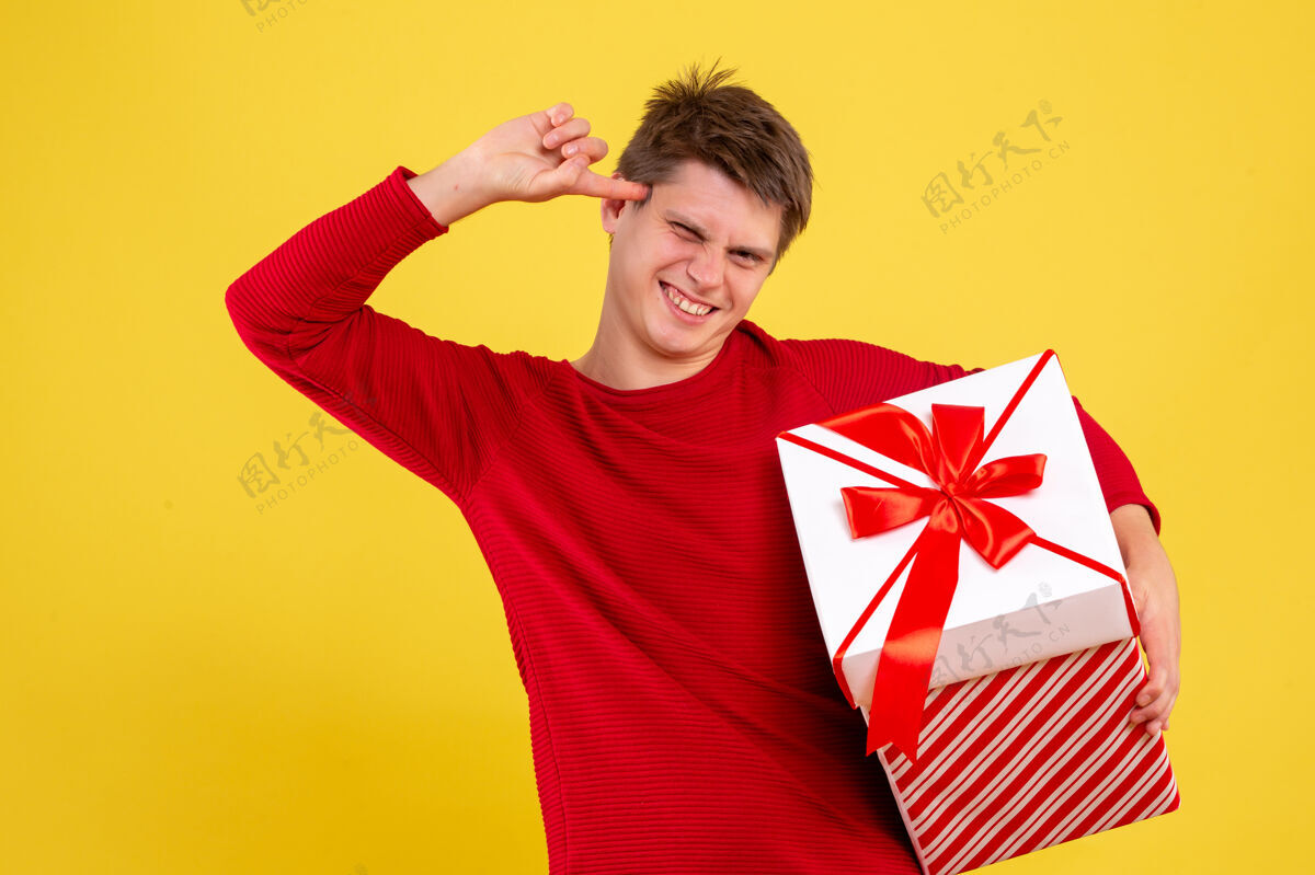 成人正面图黄色背景上有大圣诞礼物的年轻男性大微笑女人