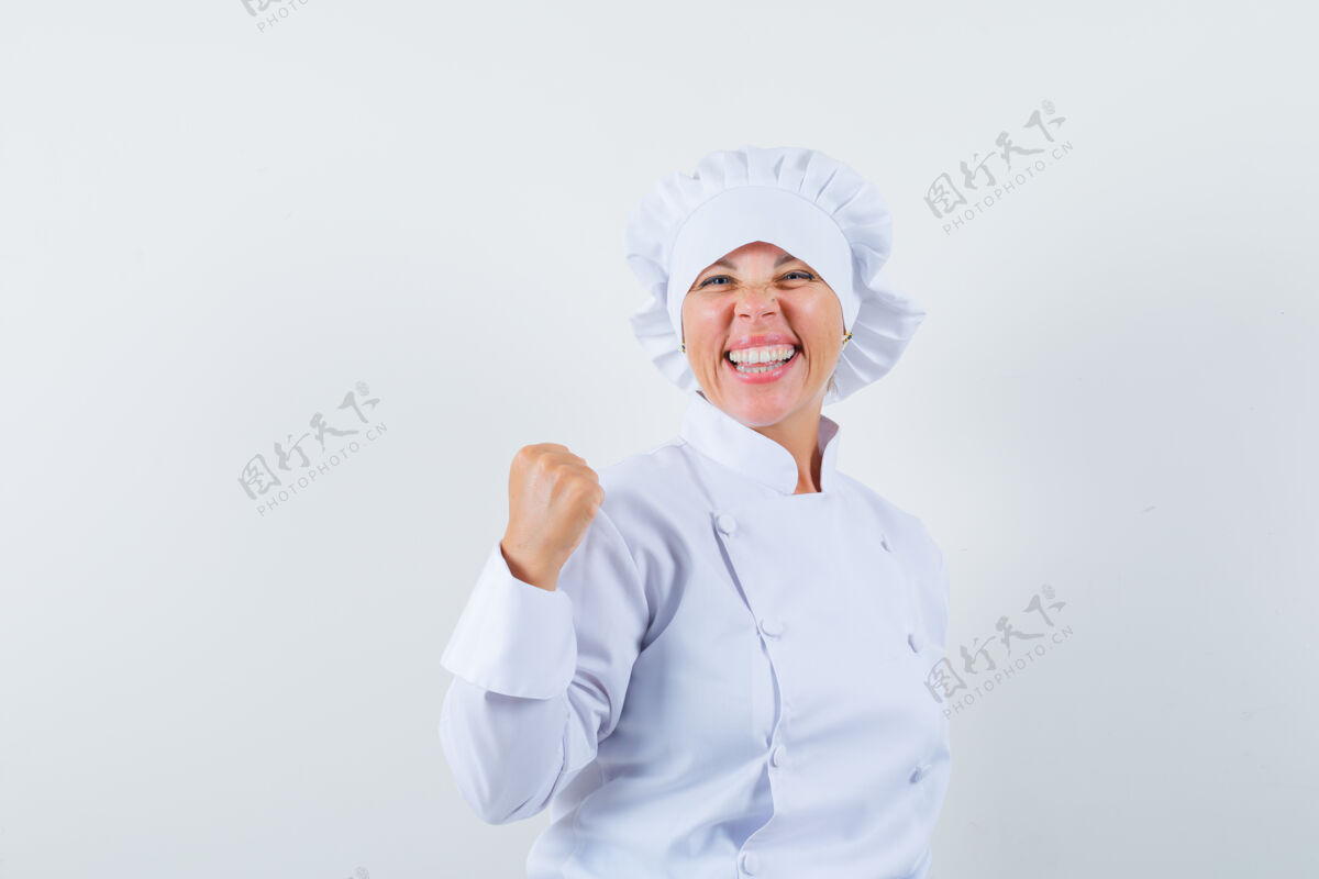 魅力身着白色制服的女厨师展示获奖者的姿态 看上去很幸运女士黑发欢呼