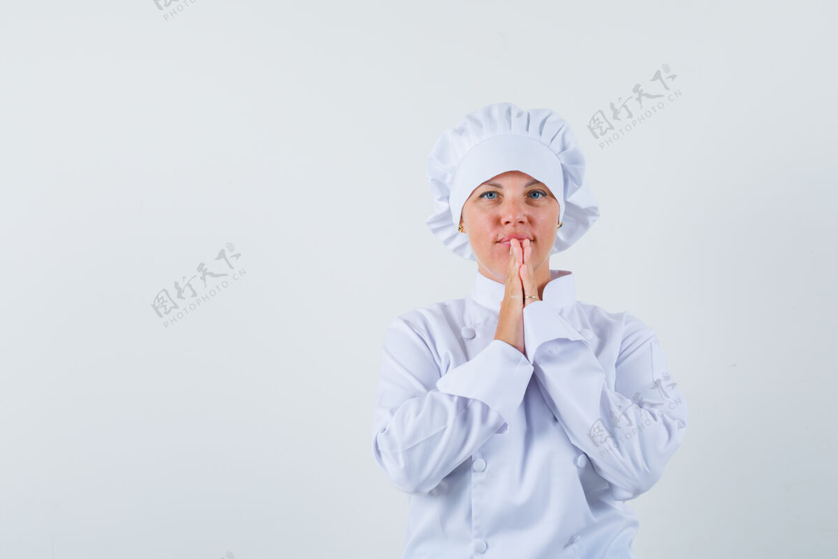 女士身穿白色制服的女厨师手牵手祈祷 看上去充满希望举行眼睛休闲