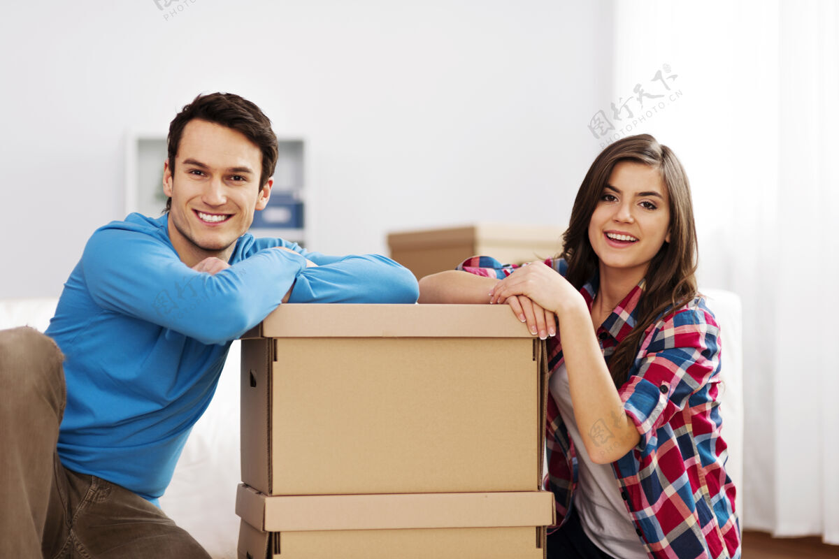 坐着带着移动盒子的年轻夫妇的画像删除团结室内