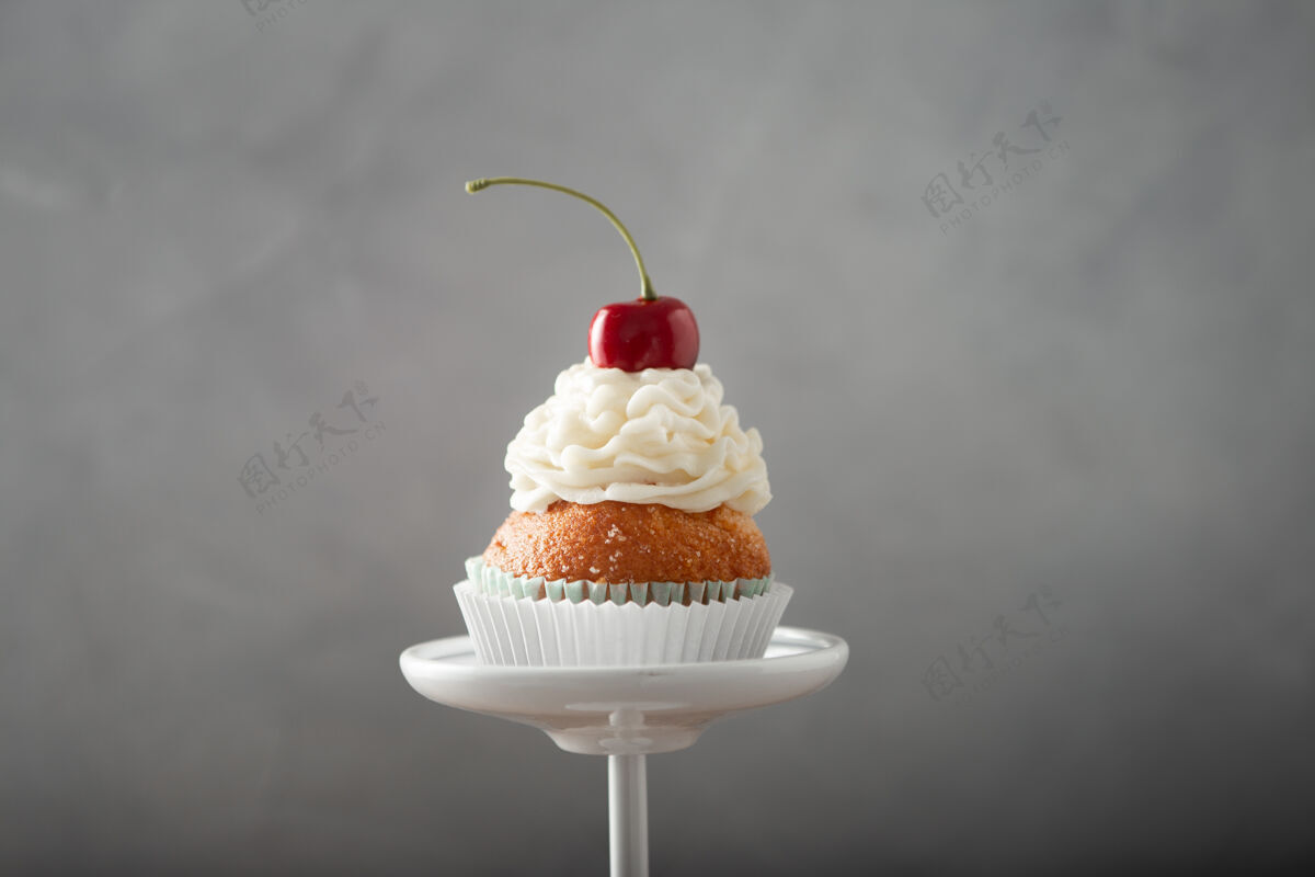 糕点特写镜头的美味蛋糕与奶油和樱桃上的甜点立场传统纸杯蛋糕美食