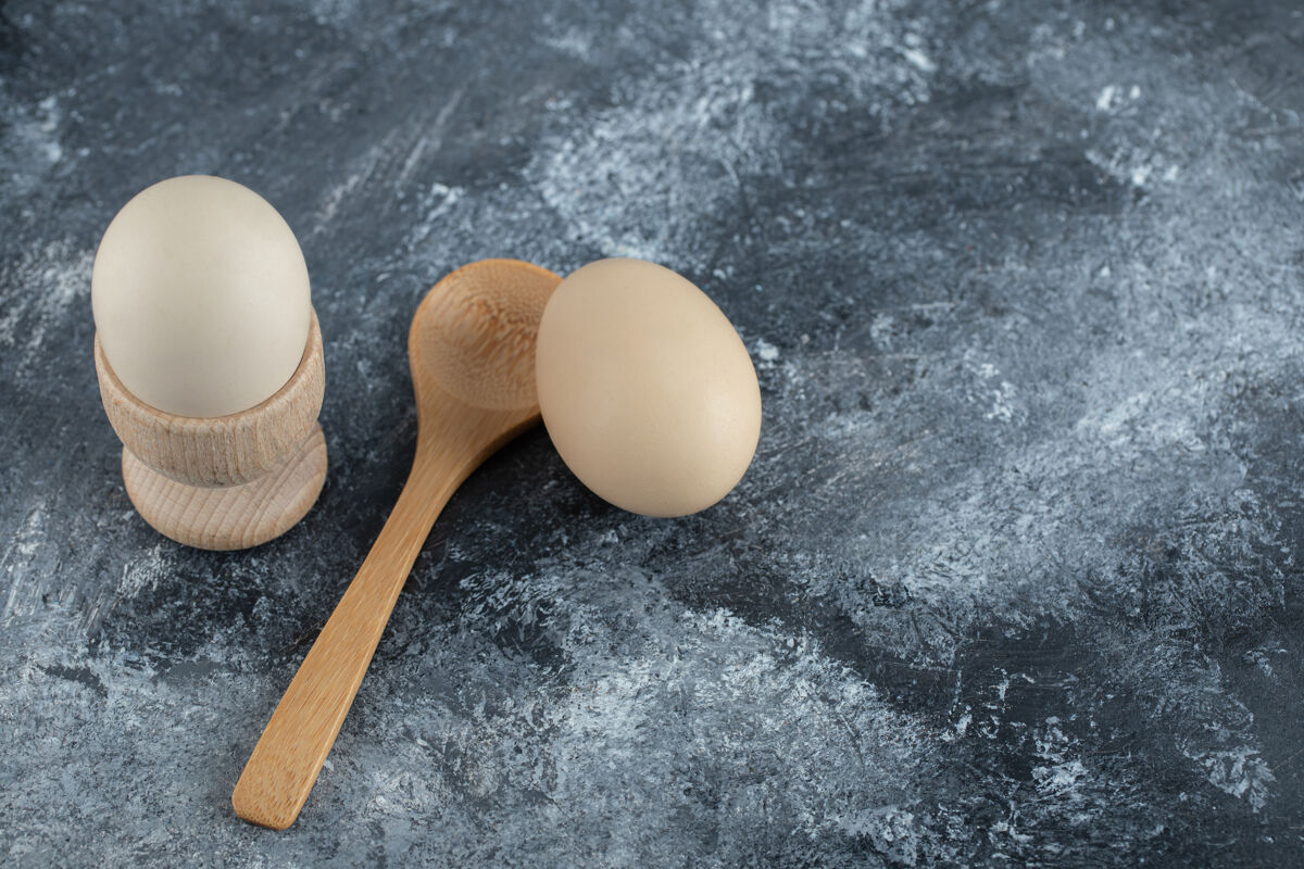 鸡蛋煮鸡蛋和木勺放在大理石上食物有机顶视图