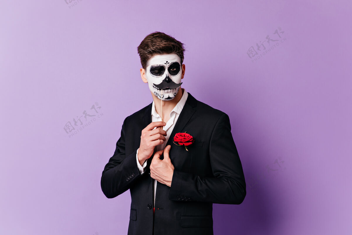 面部艺术戴着头盖骨面具的男人风骚地眨着眼睛 在孤立的背景上摆出一副叠着胡子的肖像男人墨西哥骷髅