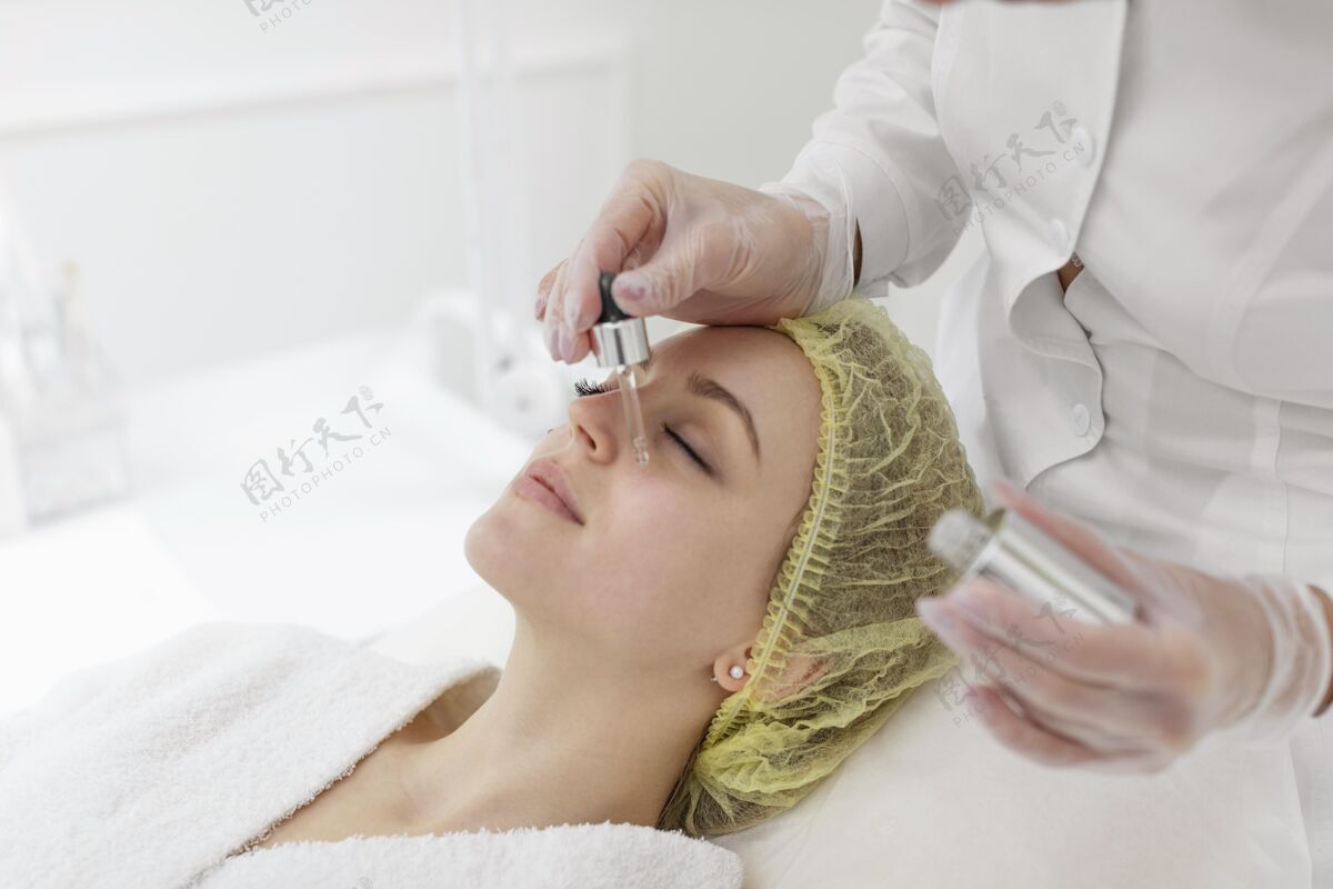 面部护理在美容诊所做面部护理的女人美容常规血清化妆品