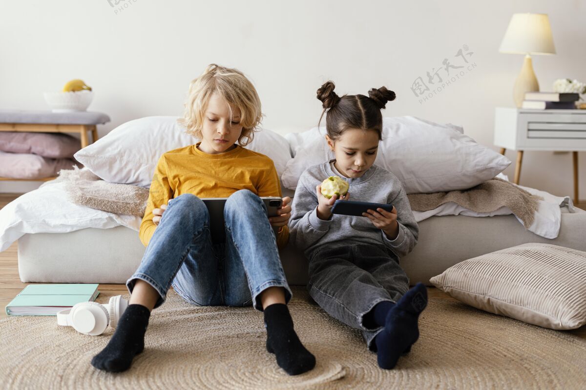 科技兄弟姐妹在床上玩手机和平板电脑兄弟姐妹手机室内