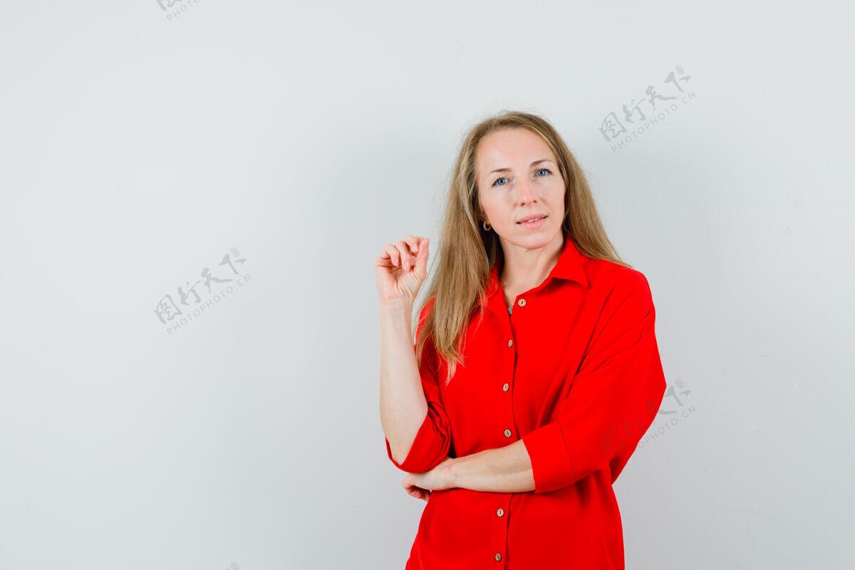 女性穿着红衬衫的金发女郎看着摄像机 神情沉思 头发时尚性感