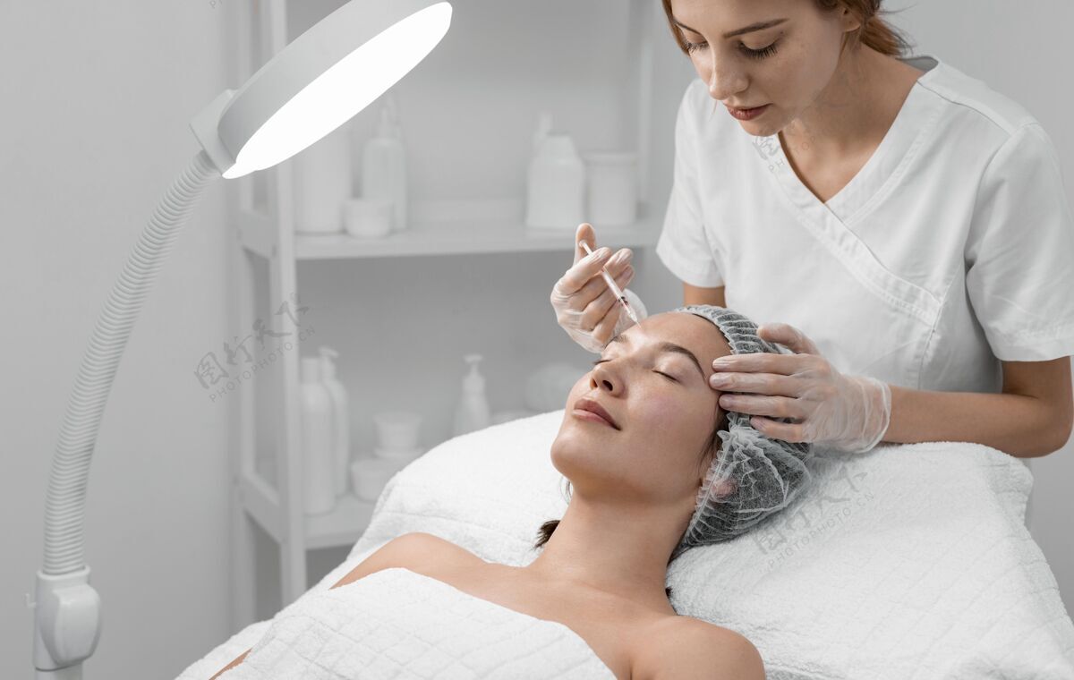 女人美容师为女性客户做填充物注射化妆品美容护理治疗