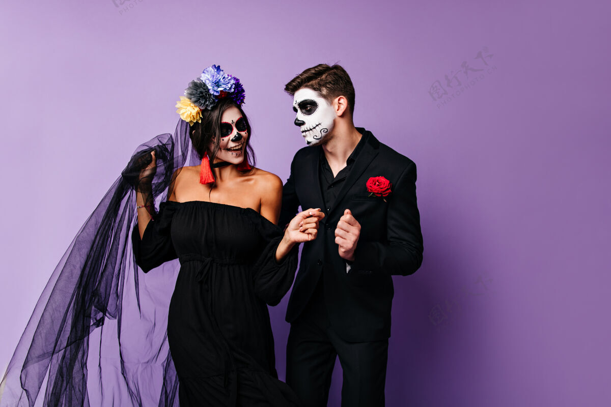 男孩室内画像 年轻女孩身穿黑色礼服 新娘和新郎在孤立的背景下 口袋里插着玫瑰跳舞骷髅男人幽灵