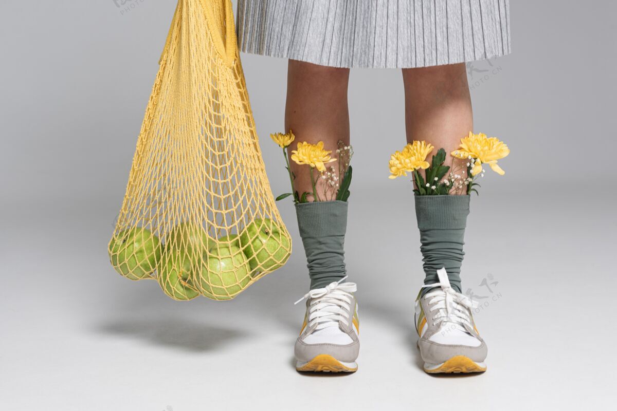 苹果特写的女人拿着乌龟袋 袜子上戴着花女人再利用回收