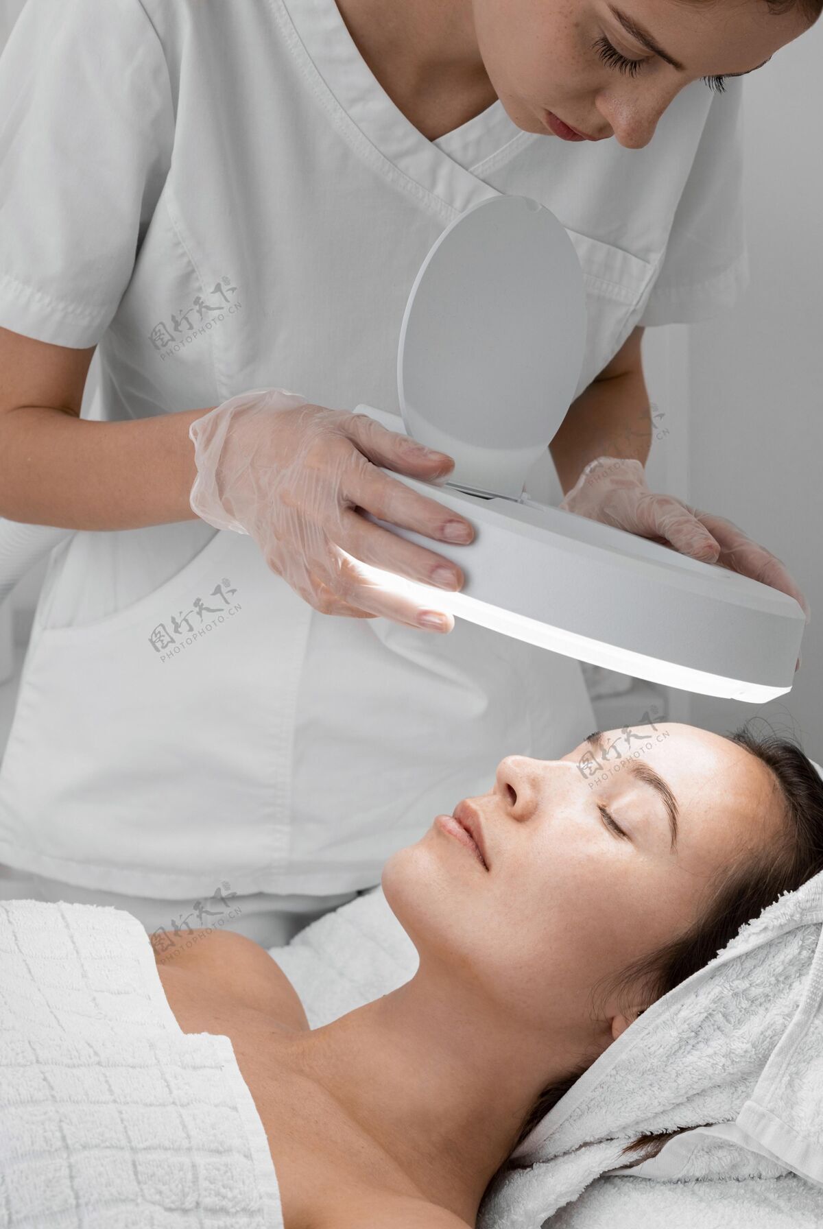 美容治疗在美容院做面部护理的女人沙龙化妆品台灯