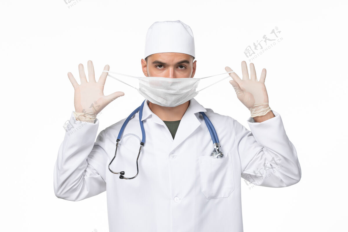 灯光正面图：男医生穿着医疗服 戴着口罩 因柯维德-轻壁病病毒柯维德-大流行病外套套装视图