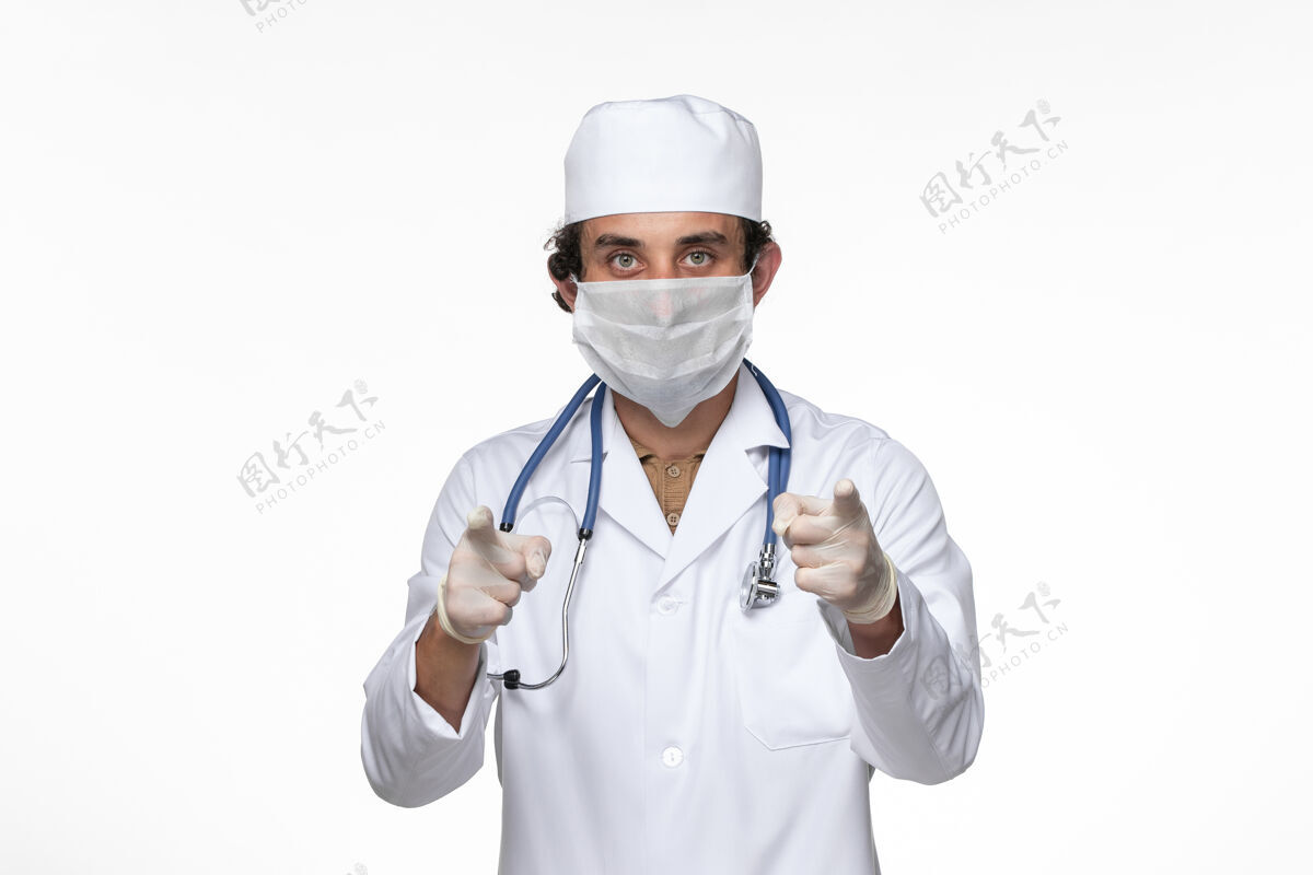 医疗正面图男医生穿着医疗服 戴着无菌口罩 以防柯维德-白墙病毒疾病柯维德大流行疾病听诊器防护男性