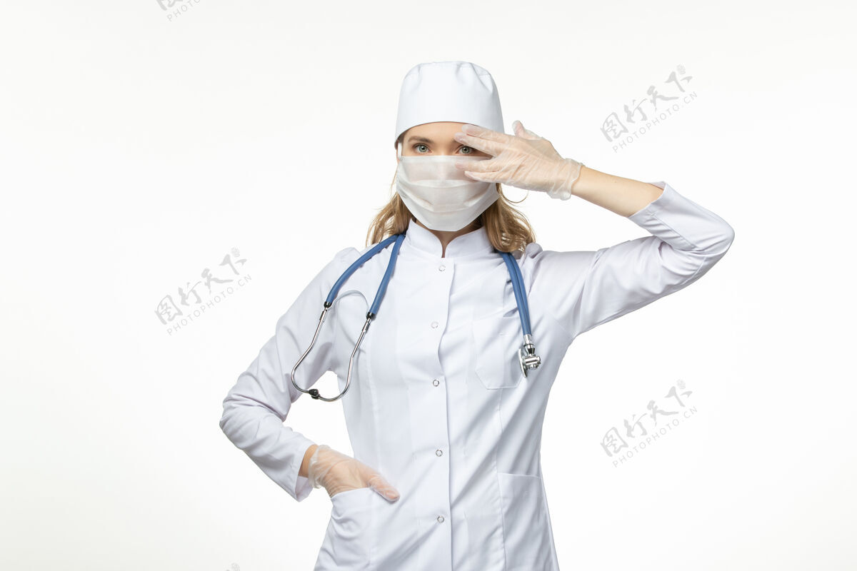 护士正面图女医生穿着医疗服戴着口罩和手套因白色办公桌上的冠状病毒病冠状病毒-大流行性疾病视图医生女性