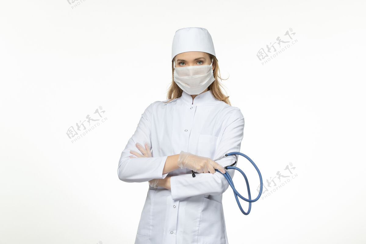 办公桌前视女医生穿着医疗服戴防护口罩因白色办公桌上冠状病毒病冠状病毒-大流行病毒病工作人员工人