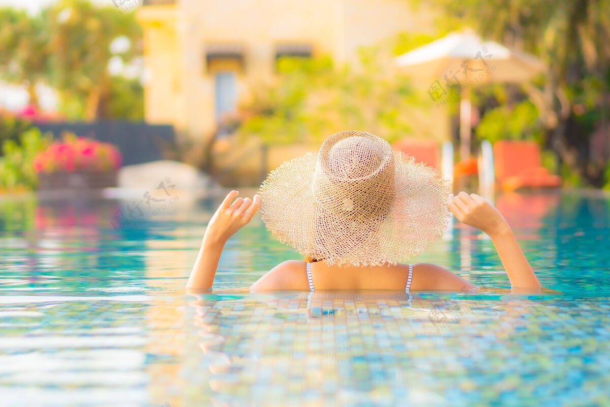 豪华肖像美丽的亚洲年轻女子放松微笑在度假酒店游泳池周围享受休闲度假海滩无限女性