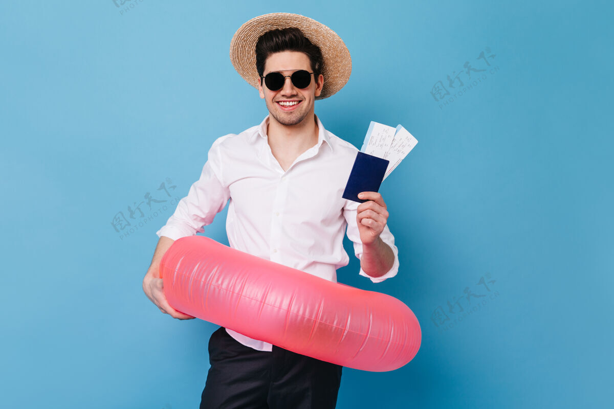 游泳蓝色空间里戴帽子戴眼镜的人的肖像穿衬衫的商人拿着休息票 护照和橡皮圈搞笑现代优雅