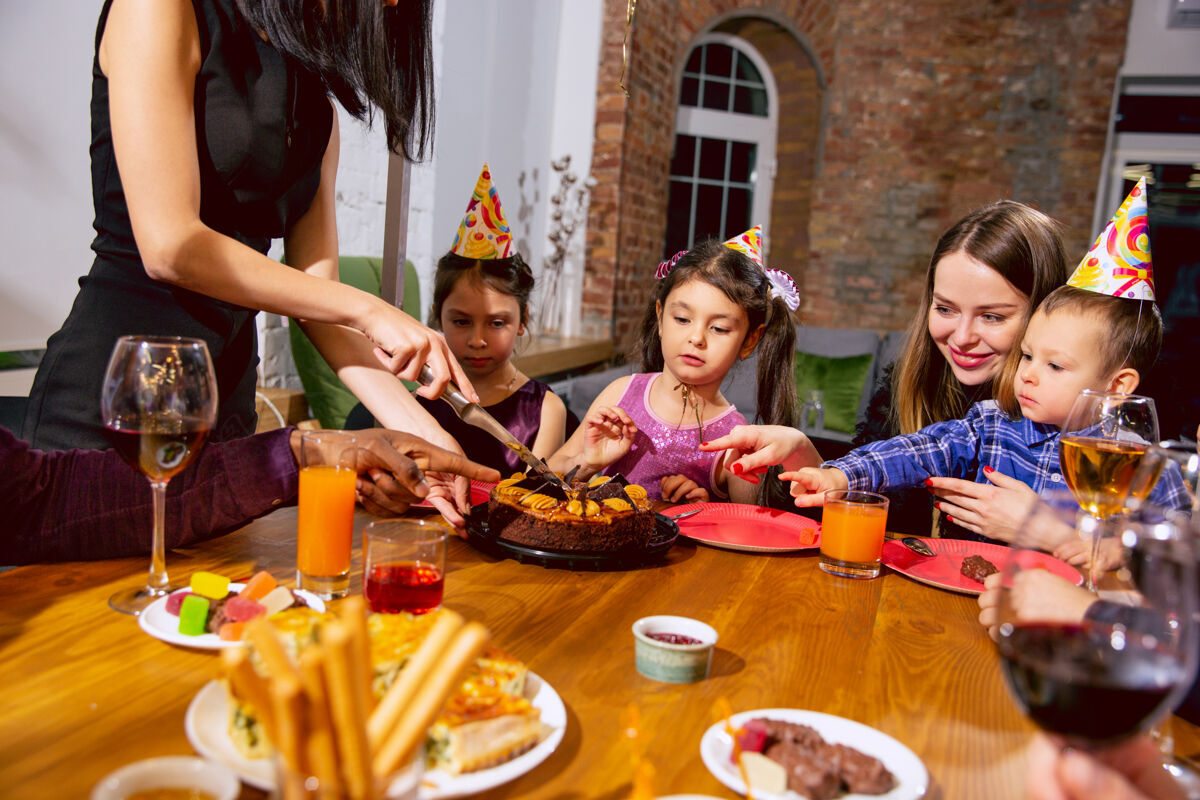 爸爸快乐的多民族家庭在家庆祝生日的画像儿子朋友零食