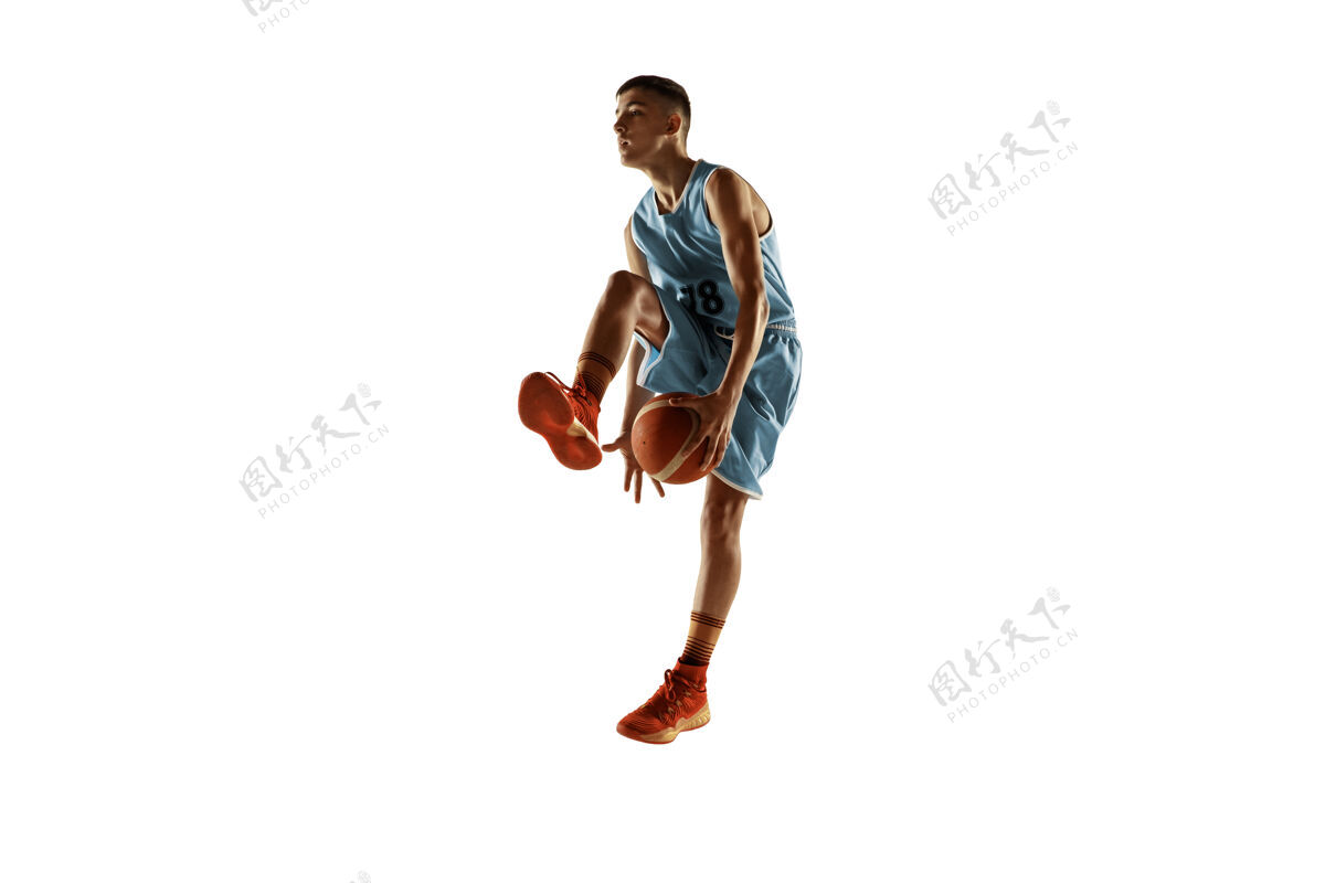 运动员一个年轻的篮球运动员与一个球在空白处孤立的全长肖像活跃运动游戏