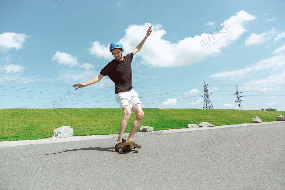 运动在阳光明媚的日子里 滑板手在城市的街道上玩花样跳跃沥青长板
