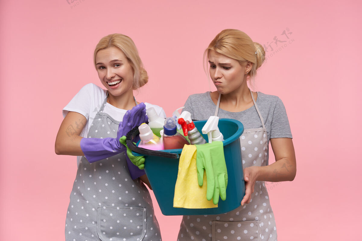金发年轻的金发可爱的主妇们戴着橡胶手套准备春季大扫除洗涤剂表情年轻