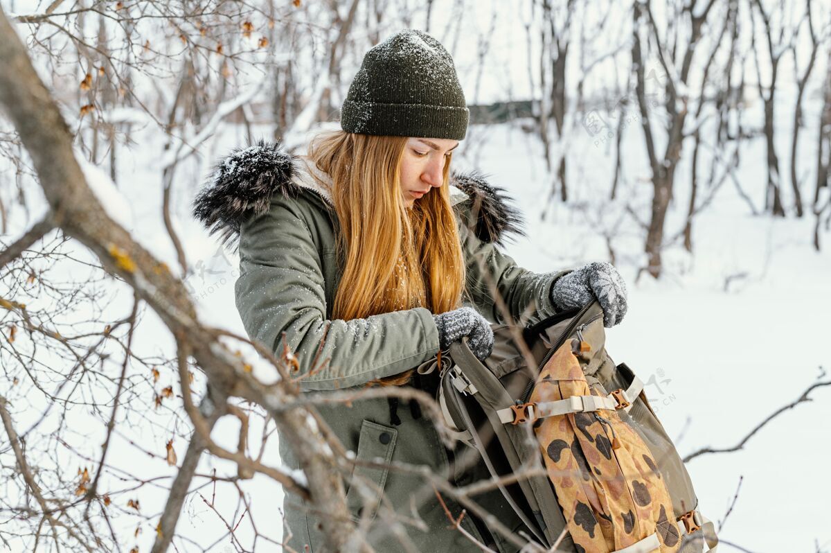 全景冬天背着背包的女人雪年轻人背包