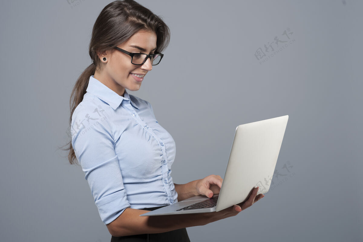 职业年轻的女商人正在使用笔记本电脑商务女性专业知识站立