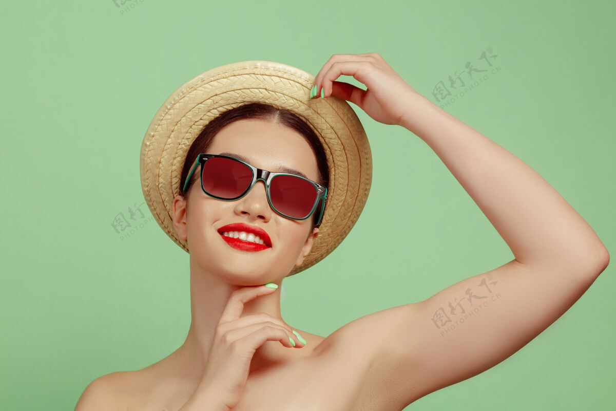 向上美丽女人的肖像 明亮的妆容 帽子和太阳镜在绿色空间时尚和时尚的制作和发型夏天的颜色头发封闭自信