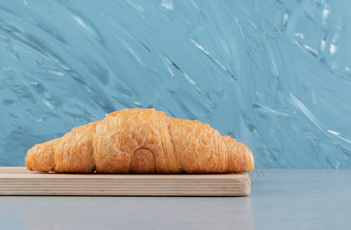 糖美味的羊角面包在黑板上 蓝色背景高品质的照片配料奶油牛角面包