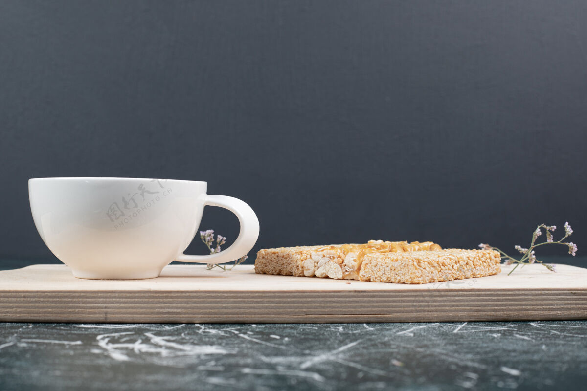 食物易碎的糖果和一杯茶在木板上高品质的照片釉料棒茶