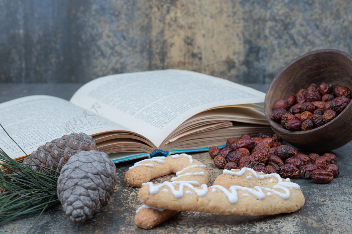 美味姜饼饼干 干玫瑰果和打开大理石背景上的书高品质的照片节日书籍甜点