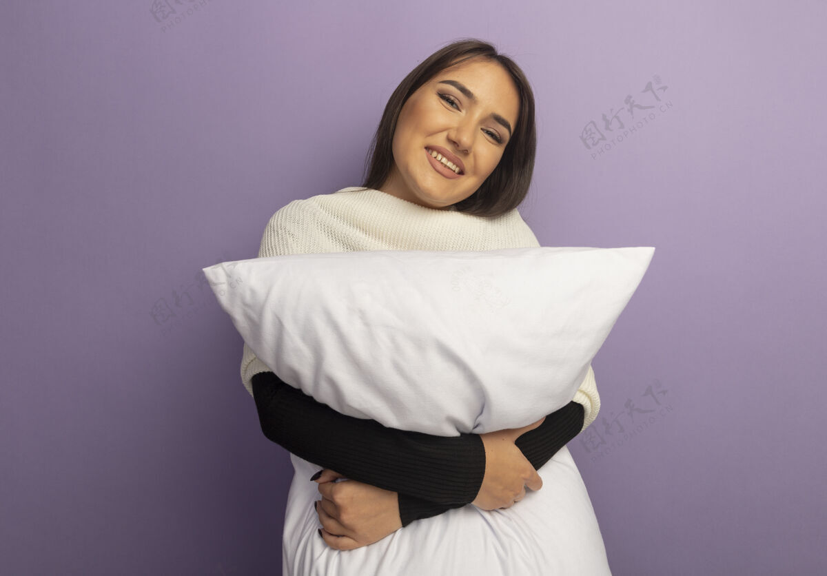 抱着抱着枕头的年轻女子快乐而积极女人年轻枕头