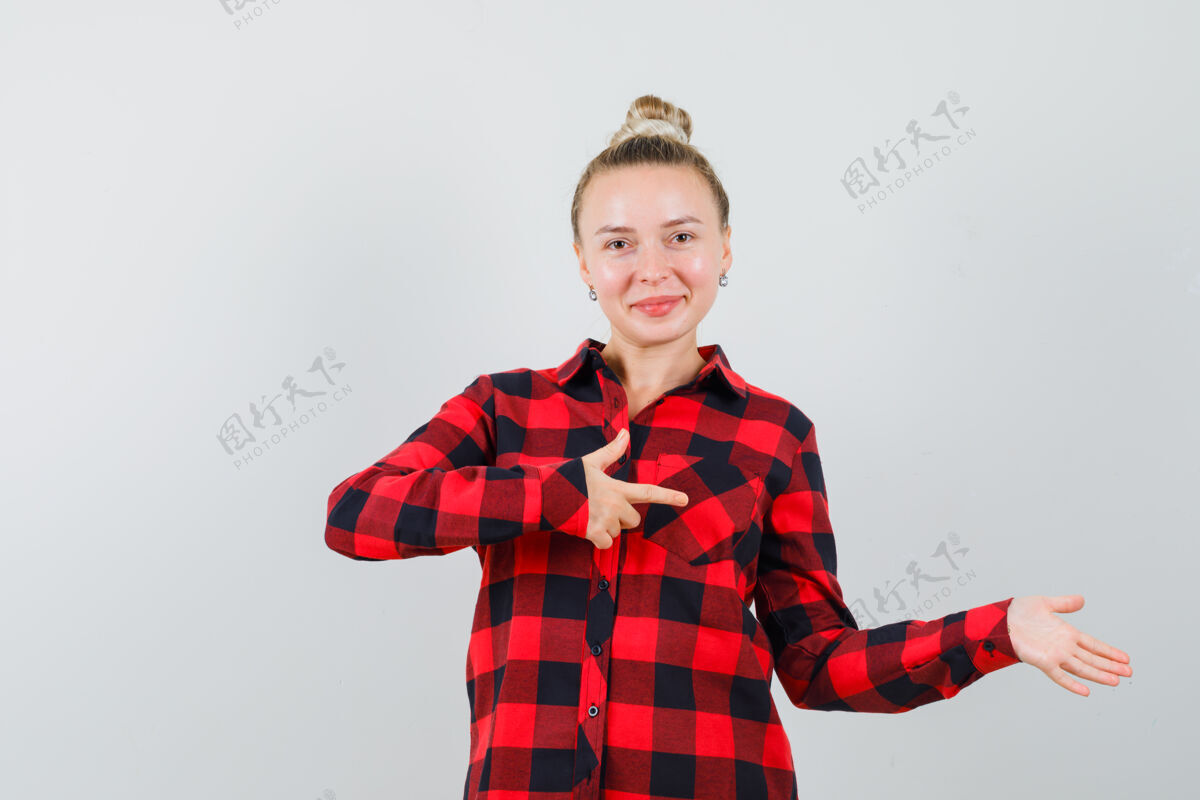 服饰年轻的女士指着旁边的格子衬衫 看起来很高兴女士快乐朋友