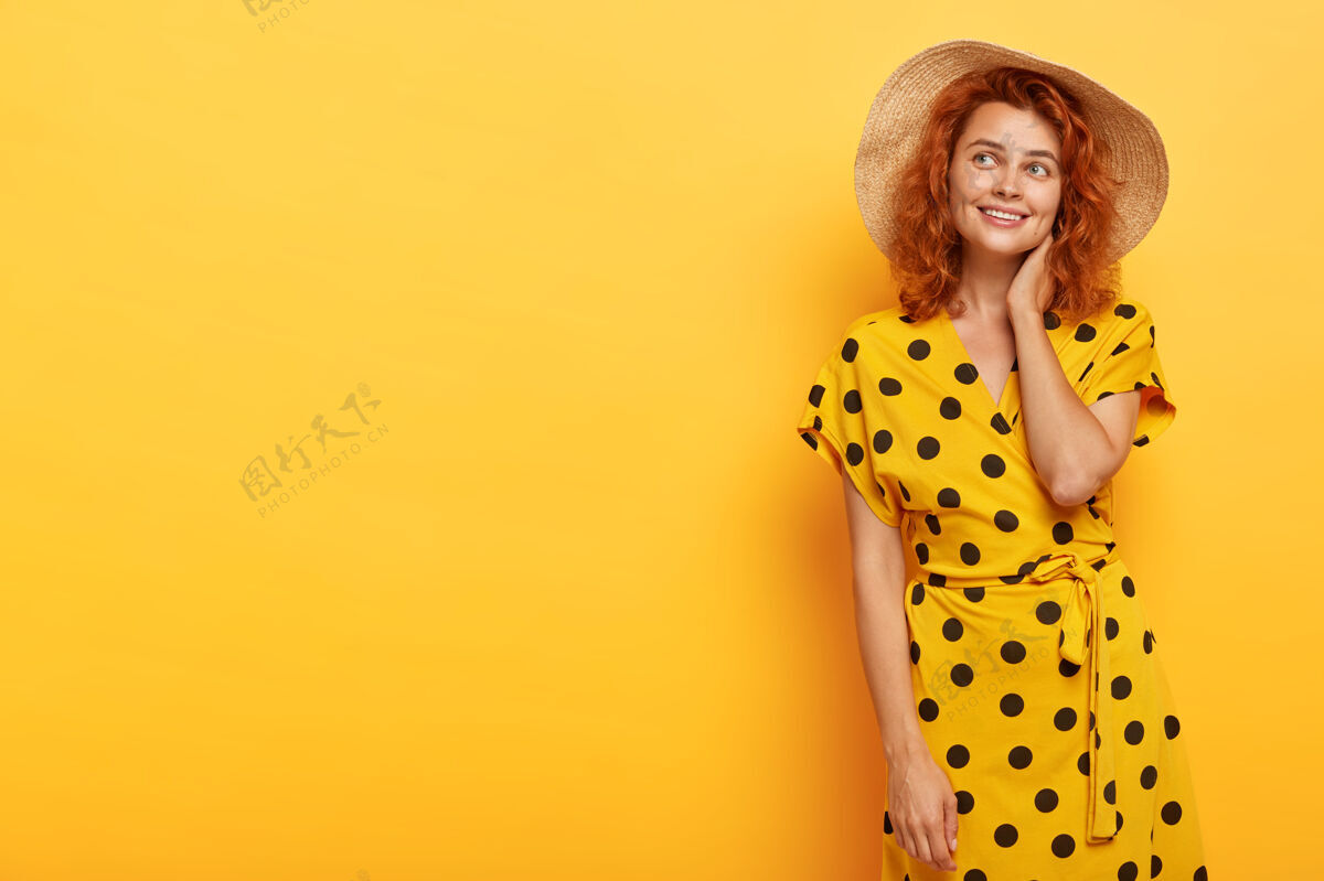 女性梦幻可爱的红发女子穿着黄色波尔卡裙 头戴草帽的照片微笑帽子时尚