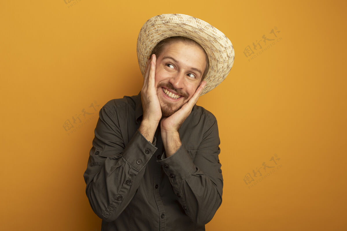 看一个穿着灰色衬衫 戴着夏帽的年轻帅哥 两臂叉开 脸上洋溢着快乐和积极手臂帽子衬衫
