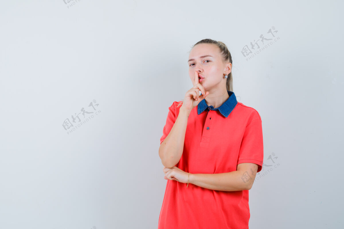 模特一个穿着t恤衫的年轻女人在做沉默的手势 看上去很小心可爱欢呼人