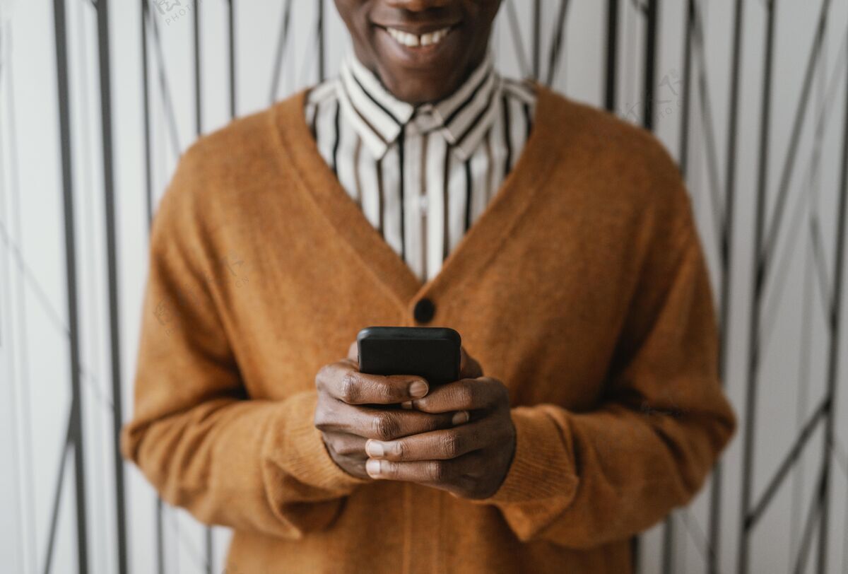 远程工作非洲裔美国人拿着他的手机非裔美国人室内现代的地方
