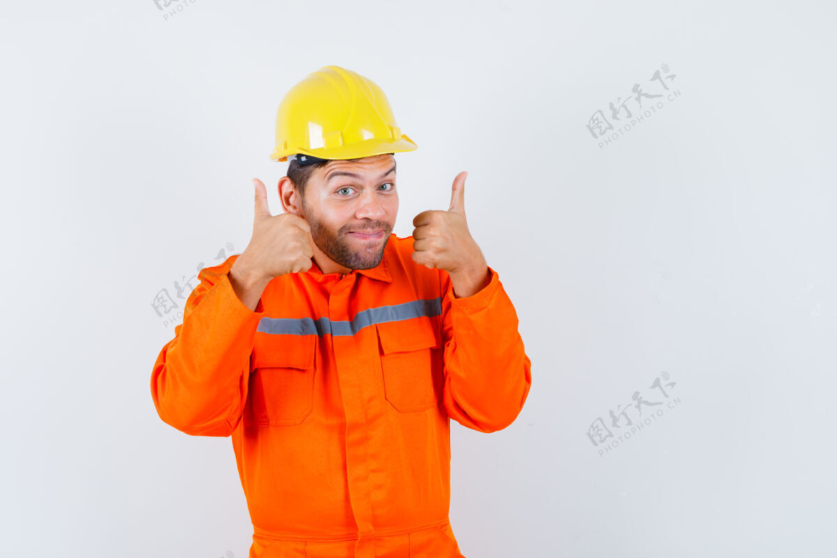 年轻年轻工人穿着制服 戴着头盔 向上竖起大拇指 看上去很积极积极显示存储
