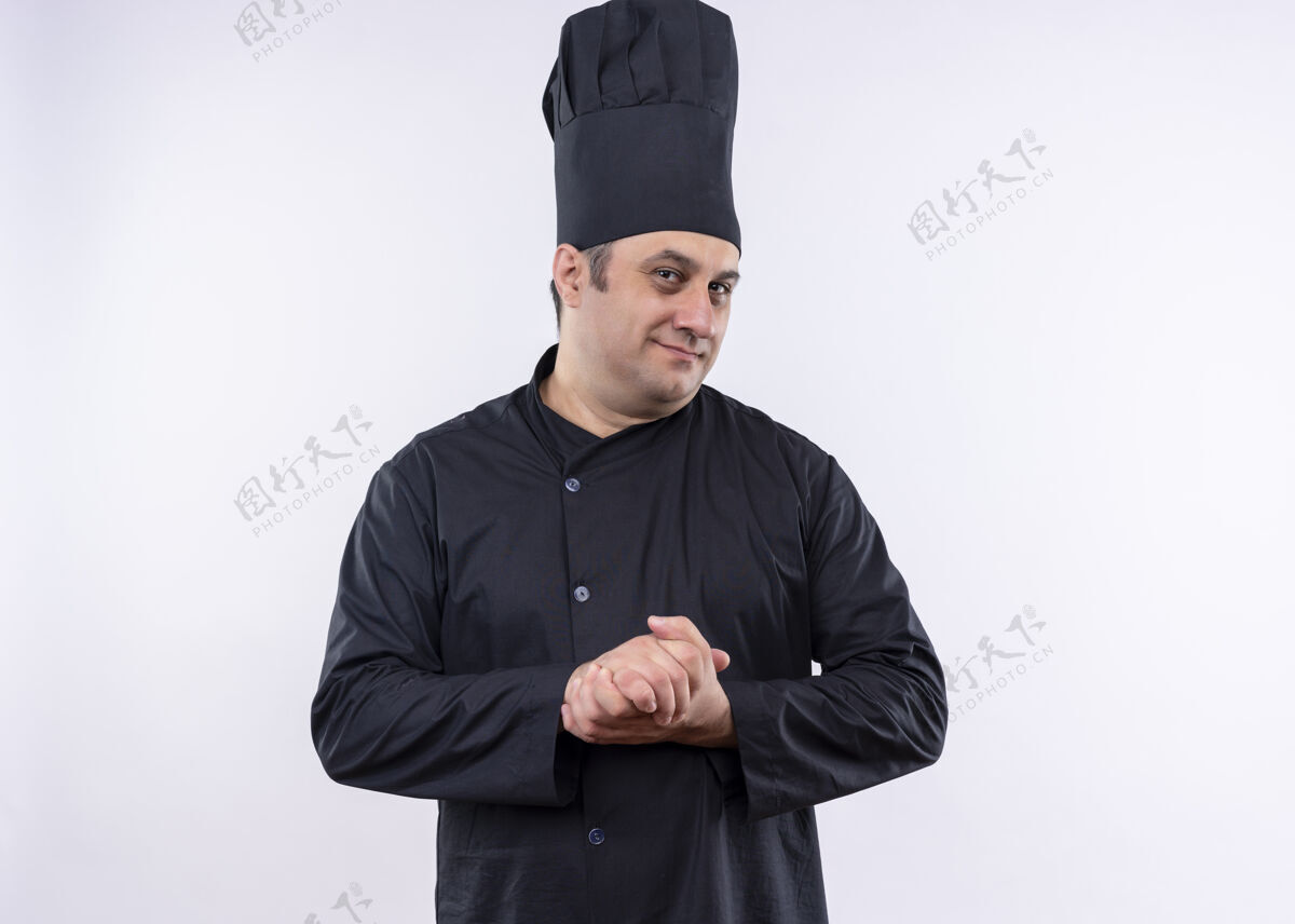站男厨师身穿黑色制服 头戴厨师帽 站在白色背景上看着镜头微笑着搓手黑微笑看