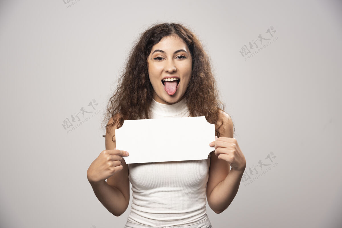成人年轻女子举着空白的白色演讲海报高质量的照片女孩人表情