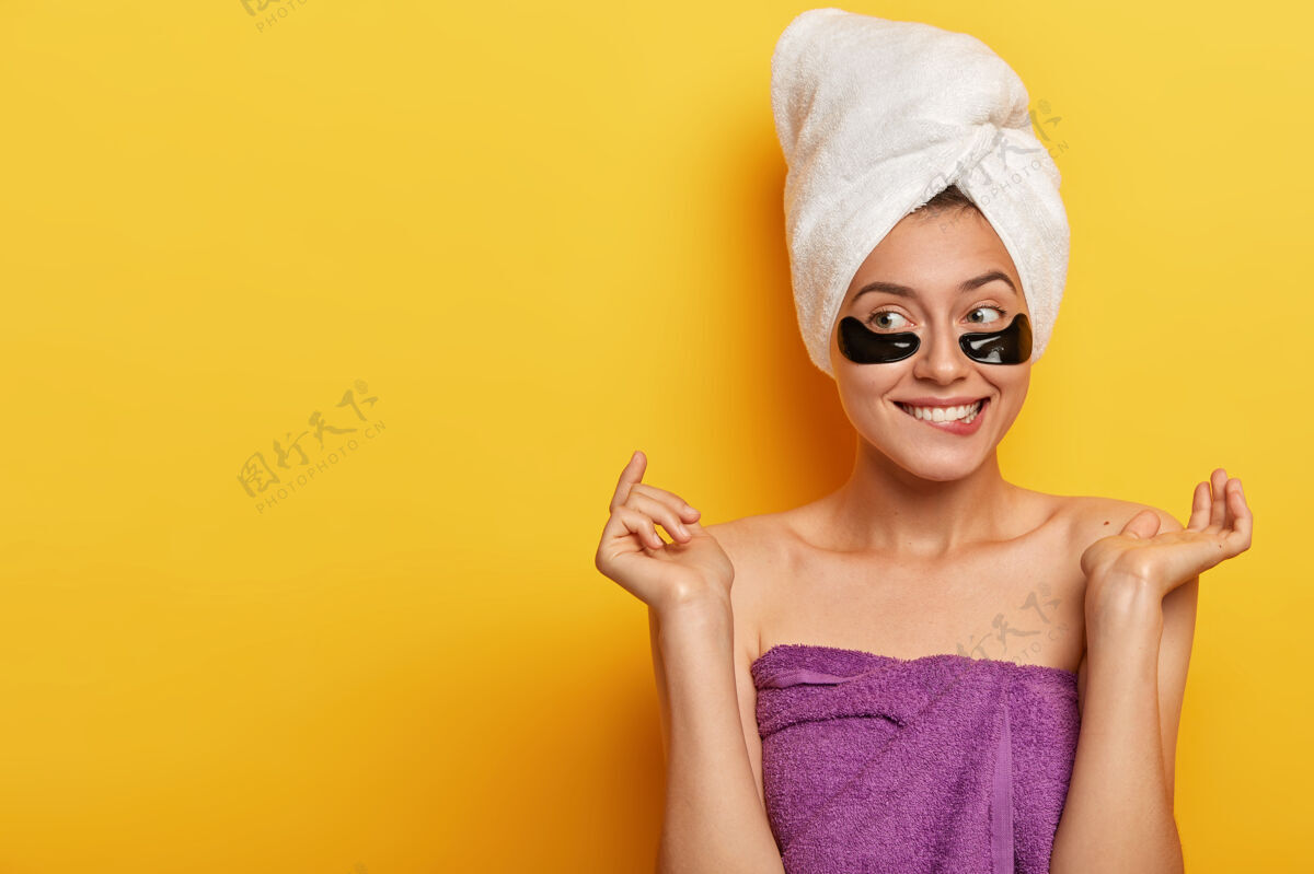 贴片快乐的白种女人从美容中得到乐趣 有问题的皮肤类型 在眼睛下面戴水凝胶贴片 减少杂质和浮肿 复制黄色墙壁上的空间胶原蛋白微笑卫生