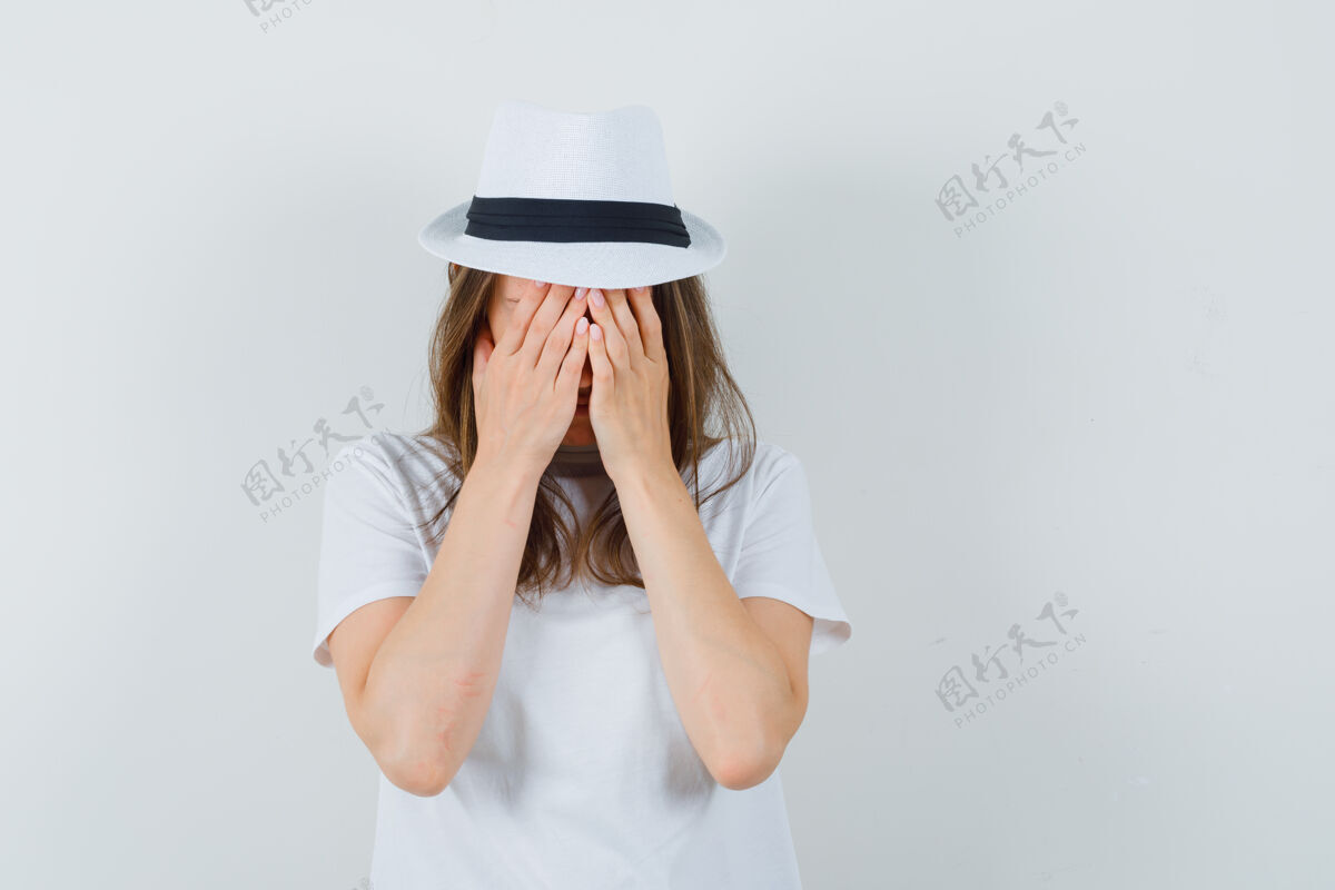 时尚一位身穿白色t恤 戴着帽子的年轻女子双手捂着脸 神情哀伤哀悼肖像女性