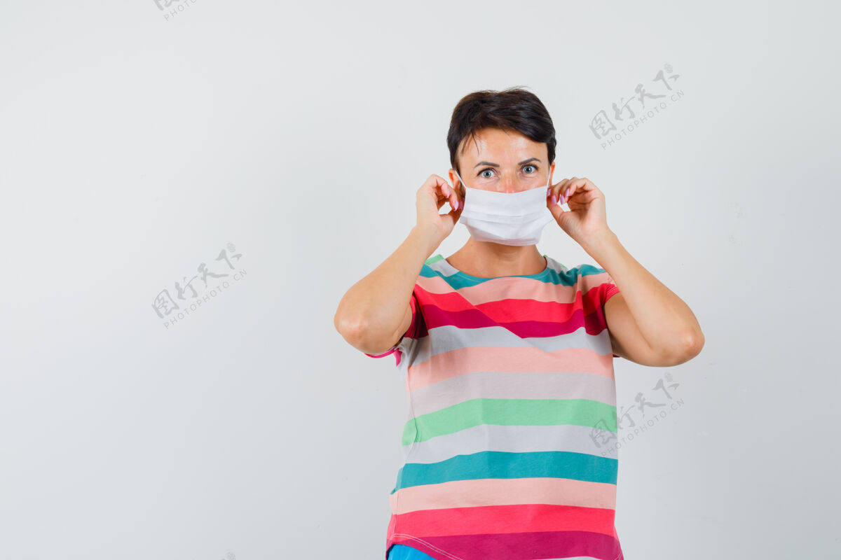 肖像戴着医用口罩的女士穿着条纹t恤 看上去很小心化妆面具时尚