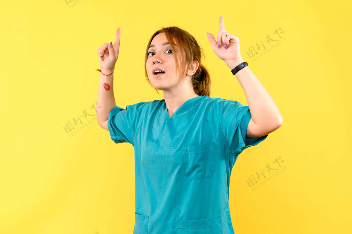 漂亮正面图女医生举起手指在黄色空间肖像女医生欢呼