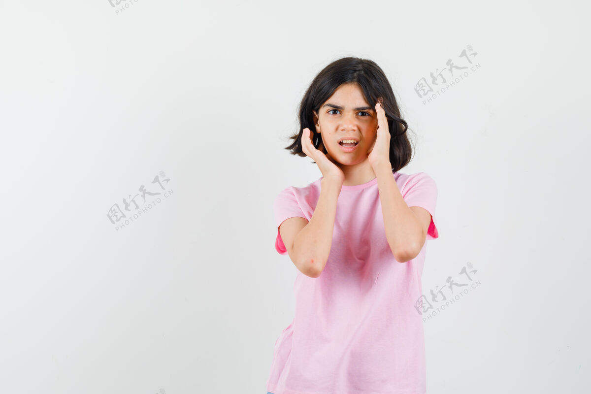 人穿着粉色t恤的小女孩手贴着脸 看起来很不满意正面图休闲未成年美丽
