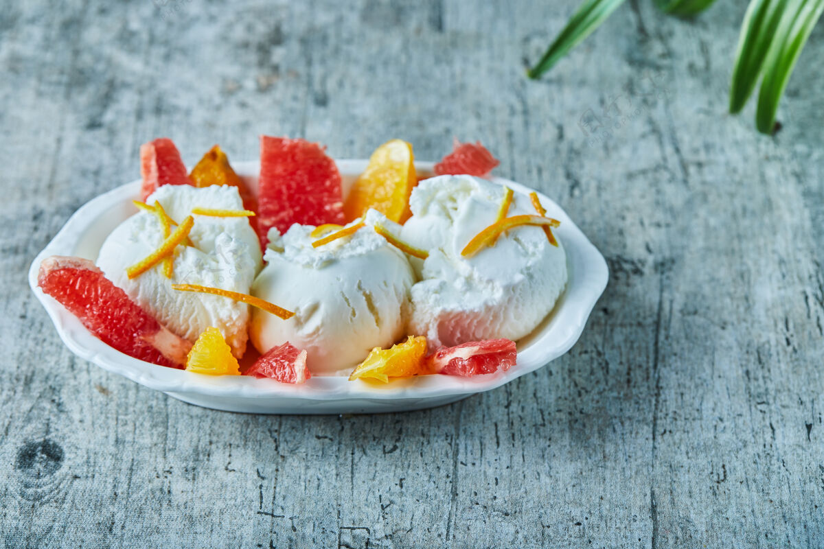 奶制品雪糕加葡萄柚和橘子片放在白碗里特写冰特写葡萄柚