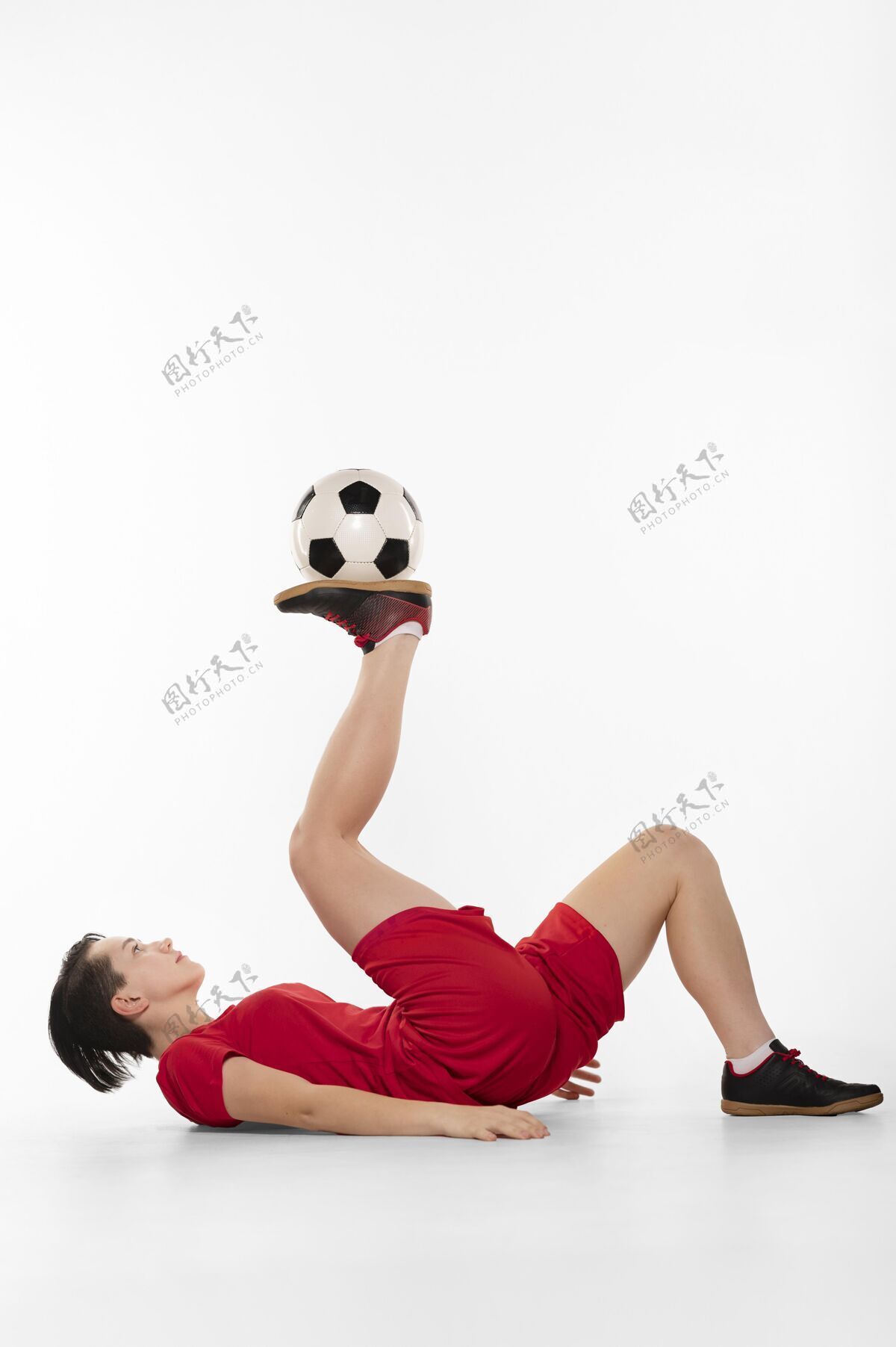 足球用足球表演杂技的女人年轻足球运动员女