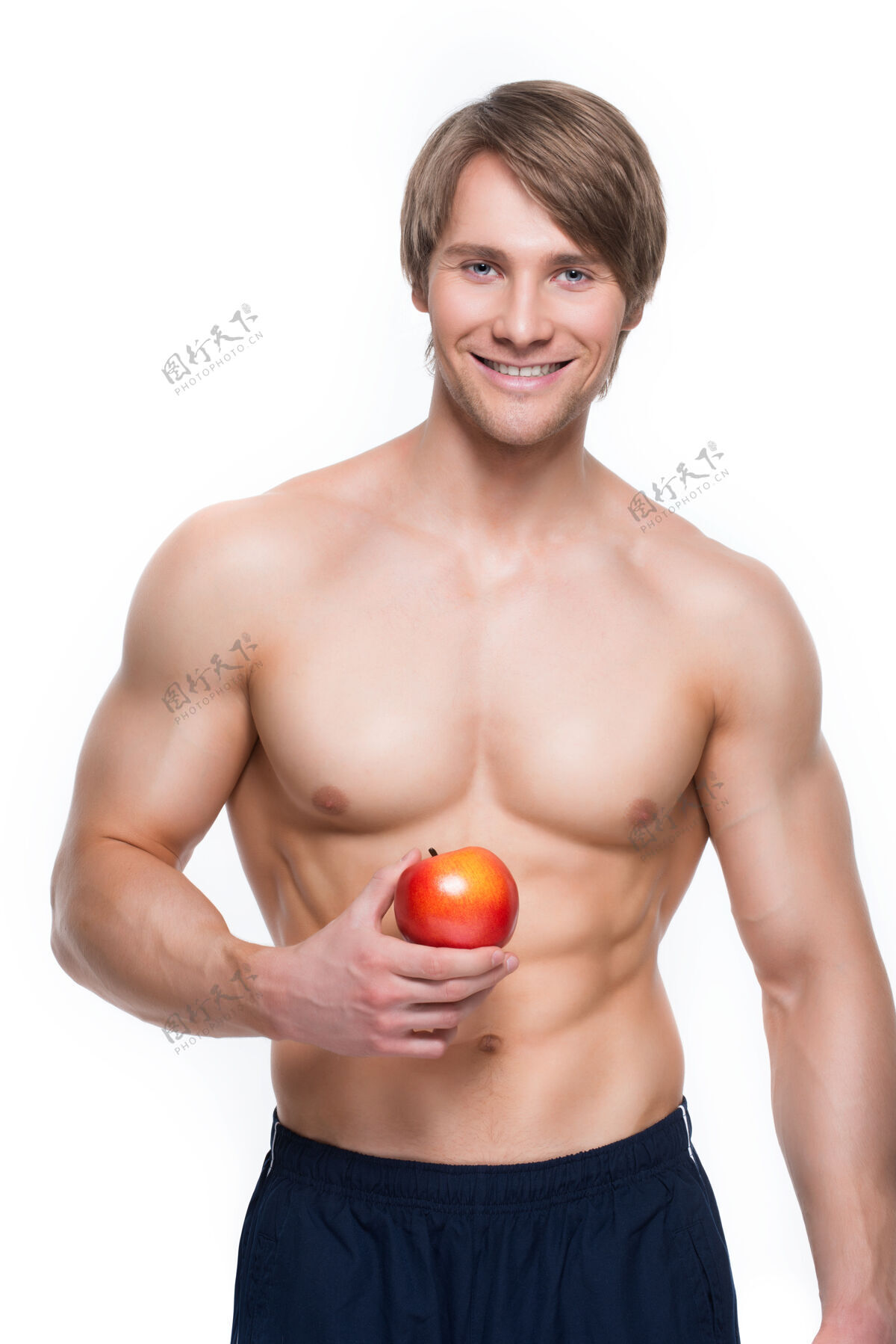 苹果年轻微笑的健美运动员手拿苹果的画像胡须牙齿肌肉